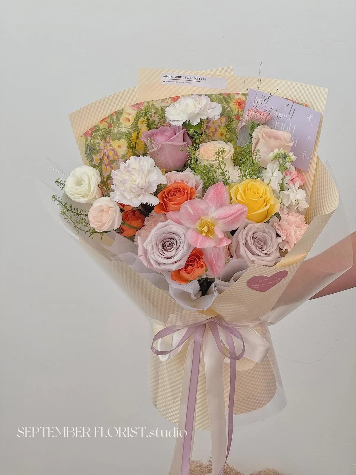 A pastel arrangement of tulips, roses and ranunculus